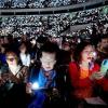 Weihnachten in Indonesien: Menschen halten elektrische Kerzen, während sie an einem Gottesdienst zu Heiligabend in Jakarta teilnehmen und  singen.