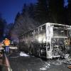 Einsatzkräfte stehen neben einem ausgebrannten Bus. Der Linienbus ist im Kreis Biberach in Brand geraten.