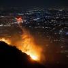 Ein Hubschrauber wirft Wasser auf das brennende Sunset Fire in den Hollywood Hills.