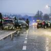 Nach einem Unfall bei Glatteis mit mehreren Fahrzeugen in Baden-Württemberg stehen Helfer und Beteiligte an den Autos auf einer Straße.