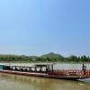 Ein «Slow boat» mit Touristen fährt über den Mekong. Die rechteckigen, bunten Holzboote tuckern gemächlich über den großen Fluss und sind sinnbildlich für die Entspanntheit in Laos.