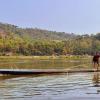 Ein Fischer wirft von seinem Longboat aus sein Netz in den Mekong.