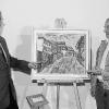 Den Blick die Hauptstraße hinauf zum alten Rathaus hat Malter Roland Kraus (rechts) in Öl festgehalten. DiesesBild und weitere Ansichten und Szenen aus Retzbach und der näheren Umgebung zeigt seine Ausstellung"Retzbach in Öl und Farbe". Sie ist noch an drei Tagen im alten Retzbacher Rathaus geöffnet. Bei der Vernissagebeleuchtete Günter Kirchner (links) die Vita des Künstlers.