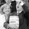 So isst man Fisch! US-Präsident George W. Bush mit einem Fass eingelegter
Heringe in der Hand, das ihm Stralsunder Fischer geschenkt hatten.
Bundeskanzlerin Angela Merkel freut sich.