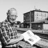 Dr.    Johannes Becker am Münnerstädter Bahnhof vor jener Bahnlinie, die im Zentrum seines umfangreichen neuen Buches steht.