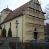 An der Westfassade der Pfarrkirche Allerheiligen in Püssensheim fällt der Putz ab.