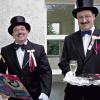 In schwarzem Frack und Zylinder präsentiert sich der Hochzeitslader hier gemeinsam mit seinem Adjutanten, Martin Zimmermann, der natürlich ebenfalls festlich gekleidet ist und auf einem Tablett Brot und Salz bereit hält.