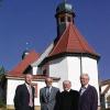 Helmut Köth vom Architekturbüro Heurich & Köth mit (links) den Pfarrern (weiter nach rechts) Edwin Ziegler und Arno Stöcklein sowie Kirchenverwalter Friedrich Ammersbach vor der alten und jetzt renovierten Garitzer Kirche St. Nepomuk.