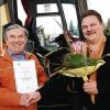 Sohn Michael Träger (rechts) überreicht seinem Vater Eberhard eine Urkunde der Industrie- und Handelskammer für 50-jähriges Betriebsjubiläum bei der Firma Greser-Reisen.