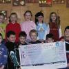 Die Teilnahme an der „Aktion Löwenzahn“ hat sich für die Grundschule Wernfeld/Adelsberg wieder gelohnt: Dr. Jürgen Raufer (hintern rechts) überreichte 100 Euro, über die sich Rektorin Anne Kade, Klassenleiterin Susanne Müller (links) und Kinder der ersten Grundschulklasse freuten.