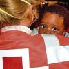 Ein Baby afrikanischer Flüchtlinge wird von einer Rotkreuz-Mitarbeiterin versorgt.