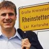 Sebastian Schrempp (CDU), Oberbürgermeister von Rheinstetten (Kreis Karlsruhe), steht vor einem Ortsschild der Stadt. Schrempp gilt als jüngster Oberbürgermeister von Deutschland. Am Sonntag ist er 100 Tage in seinem Amt.