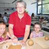 Mit viel Sorgfalt den Ton verstreichen, erklärt Rosalinde Herbert den Kindern, denn der Gartengeist soll beim Brennen nicht zerspringen, sondern voll Stolz mit nach Hause gebracht werden.