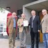 Dittelbrunn (ue)  Das Blockheizkraftwerk sendet bereits Faxe: Schulleitung, Lehrer und Hausmeister haben sich an die neue Grundschule Dittelbrunn gewöhnt. Auch der Name ist nun amtlich. Sie soll nach dem Standort „Am Sonnenteller“ heißen. Im Bild mit der Bestätigungsurkunde der Regierung von Unterfranken: Konrektor Lukas Hartung, Schulleiter Hubertus Bachmann, Bürgermeister Michael Herterich und Gemeinde-Geschäftsleiter Willi Warmuth.