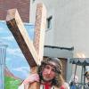 Marcello Catena trägt in Neu-Ulm als Jesus das Kreuz. DPA
