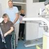 Diana Boos, Patientin der Orthopädiepraxis Knopp, wird im Rollstuhl durch die Praxis von Zahnärztin Michaela Schulze gefahren.