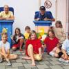 (reg)   Einen abwechslungsreichen Tag mit Organisatoren aus verschiedenen Vereinen konnten die Aubstädter Kinder am Samstag verbringen, denn sie waren in das Feuerwehrhaus eingeladen, wo bei vielen Workshops keine Langeweile aufkam. Gekocht und gebacken wurde gemeinsam in der Küche, die Teilnehmer lernten, wie man Zucchinicremesuppe und Pizzabrötchen herstellt, es wurden Muffins gebacken und Obstsalat geschnippelt. Wer wollte, konnte außerdem an einem Fahrradpannenkurs teilnehmen oder seine Mülltonne bemalen und aus der “grauen Maus“ ein buntes Unikat machen. Auch dabei hatten die Teilnehmer (hier einige der insgesamt 40 Kinder mit den Helfern Uwe Günsch (linke Tonne) und Burghard Wachenbrönner (rechte Tonne) ihren Spaß.