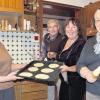 Hippenbacken in Oberweißenbrunn. Das Bild zeigt (von links): Irene Schrenk mit den aufs Backblech aufgestrichenen Fladen, Hans Schrenk, Sonja Schrenk und Ingeborg Schrenk mit dem Hippenholz.