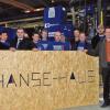 Stolz auf die neue Fertigungsanlage: Mitarbeiter und Unternehmensleitung zeigen, was die neue Maschine alles kann.