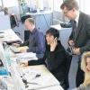 Blick ins UniCredit-Callcenter: Geschäftsführer Patrick Grünauer-Kloevekorn blickt einer Mitarbeiterin über die Schulter. Jetzt, zum 29. März, werden 150 Callcenter-Mitarbeiter der Telekom in demselben Gebäude in der Amsterdamstraße 4 eigene angemietete Räume auf drei Ebenen beziehen.
