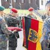 Feierliche Zeremonie: Brigadegeneral Heinrich Fischer heftet ein Band an die Truppenfahne und übergibt sie an Oberst Peter Schütz.