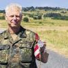 Am Kleinen Auersberg: Hauptmann Wolfgang Harke, Organisator der Wandertage im Truppenübungsplatz Wildflecken, mit der diesjährigen Medaille, die das Kapellchen bei Riedenberg zeigt.