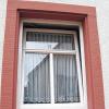 Weißer Kunststoff trifft roten Buntsandstein: Fenster dürfen in einem Altbau ruhig aus Kunststoff sein, wenn sie nicht das Gesamtbild des Hauses prägen.