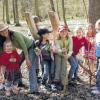 Futterstelle im Wald: Erlebnisbäuerin Stefanie Beyer zeigt Kindern, was das Wild braucht. Die Stämme im Bild dienen sowohl zum Wetzen und Scheuern als auch als mineralienreiche Salzlecke.