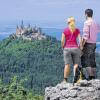 (lsw)   Der Blick auf die Burg Hohenzollern ist malerisch – und der Wanderweg dorthin ab sofort der zweitschönste Deutschlands: Das „Wandermagazin“ hat den Rundweg „Zollernburg-Panorama“ mit einer Silbermedaille ausgezeichnet. Die Medaille werde an diesem Samstag bei der Messe TourNatur in Düsseldorf verliehen, sagte der Leiter des Tourismusamts in Albstadt (Zollernalbkreis), Martin Roscher, der Nachrichtenagentur dpa. Der Panoramaweg zwischen Albstadt und Hechingen sei „schön inszeniert und voller unerwarteter Überraschungen“, sagte der Gründer des „Wandermagazins“, Michael Sänger. Neben dem berühmten Blick vom Zeller Horn auf die Burg Hohenzollern sei auch der Streckenabschnitt direkt am Albtrauf entlang „schlicht sensationell“. Der Weg gehört zu den sieben sogenannten Traufgängen rund um Albstadt. Das Netz hatte im vergangenen Jahr vom Deutschen Wanderinstitut bereits das Premium-Siegel bekommen, die höchste Auszeichnung für Wanderwege in Deutschland. Bis dahin gab es Wanderwege dieser Kategorie in Baden-Württemberg nur im Schwarzwald. Premium-Wege müssen unter anderem eine abwechslungsreiche Streckenführung haben, gut ausgeschildert sein und regelmäßige Sitzgelegenheiten am Wegesrand bieten. Insgesamt hätten sich 100 Wanderwege für die Auszeichnung als schönster Weg in Deutschland beworben. Dass der Panoramaweg aus Albstadt gleich im ersten Jahr nach seiner Eröffnung die Silbermedaille bekomme, sei eine großartige Erfolg, sagte Roscher. Seit der Eröffnung der Traufgänge im vergangenen Jahr verzeichnen die Tourismusbetriebe nach Angaben der Stadt Albstadt deutlich mehr Gäste. Vor allem Touristen aus der weiteren Umgebung kämen häufiger zu einem Wochenendausflug auf die Alb. Als schönsten Weg in Deutschland zeichnet das „Wandermagazin“ den Traumpfad Monrealer Ritterschlag in der Eifel aus, die Bronzemedaille bekommt die Baybachklamm-Tour im Hunsrück.