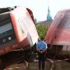 Rettungskräfte stehen nach einem Zugunglück in Lauterbach bei Bad Lausick (Kreis Leipzig) am Dienstag (20.09.2011) neben dem verunglückten Zug.
