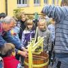 Unterricht mal anders: Hermann Fischer zeigt den Saaletalschülern, wie man Apfelsaft presst.