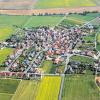(wh)  Etwa 340 Bürger wohnen in Heßlar. Vor 50 Jahren war der Ort auf dem luftigen Berg noch schlecht an das Straßennetz angebunden. Heute führen viele Straßen nach Heßlar, das seit 1978 ein Stadtteil von Karlstadt ist. Von rechts (Süden) führt die Straße aus Thüngen vorbei an Reit- und Fußballplatz in den Ort. Links (Norden) führen Straßen am alten Kindergarten und Aussiedlerhof Höfling nach Bühler und vorne in westlicher Richtung nach Schönarts, Karlstadt und Stetten. Zum Altort gehören das Dorfzentrum und das Sportheim des TSV Heßlar. Kirche und Friedhof St. Michael sowie das frühere Gasthaus Adler. Die Schule, der Kaufladen und die Poststelle belegen einen Ortskern mit guter Infrastruktur. Dem Altort schließt sich nahtlos die neue Siedlung an, die derzeit schon aus mehr als 30 neu erbauten Wohnhäusern besteht. Das Bild entstand im Frühsommer