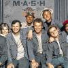 Profis in Sachen Spott und Satire: „Hawkeye“ Pierce (Alan Alda, Dritter von links) mit Major Frank Burns (Larry Linville), Major Margaret „Hot Lips“ Houlihan (Loretta Swit), Lieutenant Colonel Henry Blake (McLean Stevenson), „Trapper John“ Captain John McIntyre (Wayne Rogers), Father Francis Mulcahy (William Christopher) sowie den Corporals „Radar“ O'Reilly (Gary Burghoff) und Maxwell Klinger (Jamie Farr).