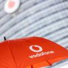 Ein Passant geht mit einem aufgespanntem Regenschirm mit dem Logo von Vodafone an der Zentrale der Deutschlandtochter des britischen Vodafone-Konzerns vorbei.