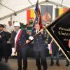 Ehrenmitglied Georg Seufert, Pate der Fahne der Freiwilligen Feuerwehr Unterspiesheim hält die enthüllte Fahne.  Sie zeigt auf der Vorderseite das Ortswappen von Unterspiesheim und die Flamme, das Logo der FFW Unterspiesheim. Das Wappen und die Flamme sollen die Verbindung zwischen Vergangenheit und Zukunft symbolisieren.