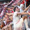 Thomas Müller steigt nach dem Bayern-Sieg auf den Zaun zu den Fans.