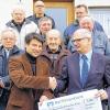 Flurbereinigung abgeschlossen: Andreas Kaiser (links), überreichte an Bürgermeister Richard Knaier einen Scheck in Höhe von 5800 Euro, der dem Erhalt der gemeindlichen Anlagen dienen soll. An der Feierstunde nahmen Werner Hemmert, Franz Ebert (2. Reihe von links), Wegebaumeister Karl Heuering, Rudolf Strauß, Anton Dünisch (3. Reihe von links) sowie stellvertretender Bürgermeister Gerald Heuering (hinten links) und Libor Oppel (hinten rechts) teil.