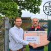 Andreas Roos (Geschäftsführer Roos Homecare GmbH) übergibt den symbolischen Scheck an Rainer Schöpplein (Abteilungsleiter Segeln des 1. SCS13) und Gebhard Riegler (stv. Abteilungsleiter). Von links nach rechts:  Andreas Roos - Gebhard Riegler - Rainer Schöpplein.