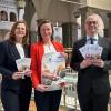 Oberbürgermeister Dirk Vogel (rechts) präsentiert den Flyer zu den Gesundheitswochen zusammen mit der Geschäftsleiterin der Bayerischen Staatsbad Bad Kissingen GmbH Kurdirektorin Silvie Thormann und der Projektverantwortlichen der Stadt Bad Kissingen Stefanie Maessen.