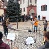 Bürgerinnen und Bürger mit ihren Kindern versammeln sich zum Singen unterm Weihnachtsbaum.