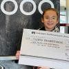 Lia, Enkelin von Regina Drigo (Inhaberin von Eis2000 in Heidingsfeld), präsentiert den Spendenscheck über 1150 Euro für das Malteser Kinderpalliativteam Unterfranken.