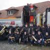 Die Familie Einbecker und ein Teil der Musikerinnen und Musiker des Musikvereins Knetzgau bei der Übergabe der neuen Softshell-Jacken.
