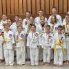Sensei Michaela Lorenz (Trainerin), Matthias Schneider (Vorstand Verwaltung TSV Rottenbauer), Sensei Andrea Winkler (2. Abteilungsleiterin und Trainerin), Matthias Purucker (Vorstandsvorsitzender TSV Rottenbauer), Sensei Lea Winkler (Trainerin) und Shihan Patrick Paolozzi (1. Abteilungsleiter und Trainer) - dazwischen in den weißen Gis die erfolgreichen Teilnehmer und Platzierten.