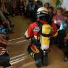 Ein Atemschutzgeräteträger der Freiwilligen Feuerwehr Werneck präsentiert den gespannt folgenden Kinderaugen seine Schutzausrüstung.