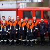 Die Feuerwehrleute nach der Leistungsprüfung vor dem Löschfahrzeug mit den Schiedsrichtern und Kommandant, Gruppenführer Christoph Koberstein (zweiter von links in der blauen Warnweste) und Bürgermeister Johannes Wagenpfahl (rechts). 