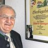Pfarrer Heininger vor der Urkunde, die ihn als Ehrenbürger von Großbardorf ausweist.