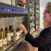 Beate Glotzmann, Leiterin der Tourist-Information und der dazu gehörigen Vinothek in Gerolzhofen, lässt sich vom Wein-Dispenser einen Bacchus zum probieren ausschenken.