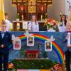 Nach dem Festgottesdienst stellten sich die Waldzeller Kommunionkinder vor ihrem großen Reliefbild mit dem Regenbogen über ihrer St. Vituskirche auf (von links) Vincent Hock, Marvin Möhler sowie Hannes Gläser mit Pfarrer Olzewski und dahinter die Ministranten.