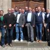 13 Bürgermeister der NES-Allianz, die ILE-Umsetzungsbegleiterinnen und die Betreuerin des Amts für ländliche Entwicklung vor dem Portal der Schule für Dorf- und Flurentwicklung in Klosterlangheim
