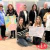 Präsentieren Scheck und Kunstwerke (hinten von links) Pia Bundschuh, Margarethe Mark, Marion Frischholz, Friederike Frank, Joachim Beck und Sonja Fischer-Seitz, sowie eine Schülervertretung der Realschule Maindreieck.